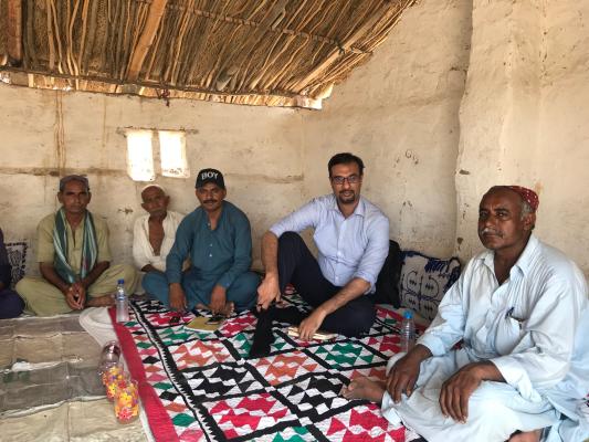 Photo of Dr Tayyab Safdar with local men during his fieldwork research 