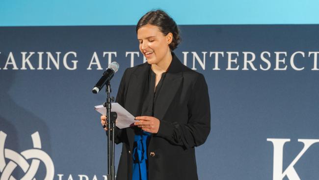 Image of Amy Wolstenholme reading her poem at the London Peace Symposium